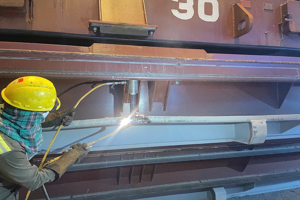 VNS technician repairing a hatch cover guide rail aboard a vessel
