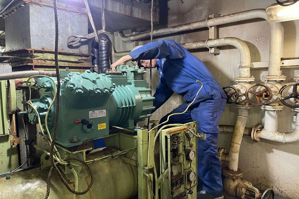 VNS technician servicing a refrigeration compressor aboard a vessel