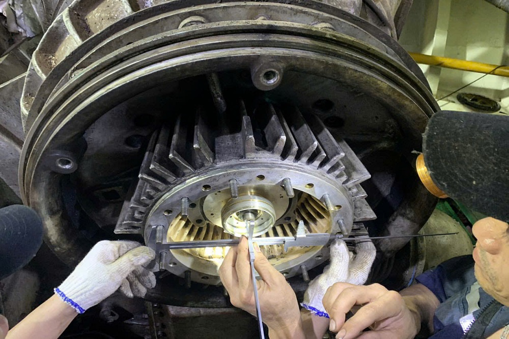 Technician taking measurements on a generator after overhaul